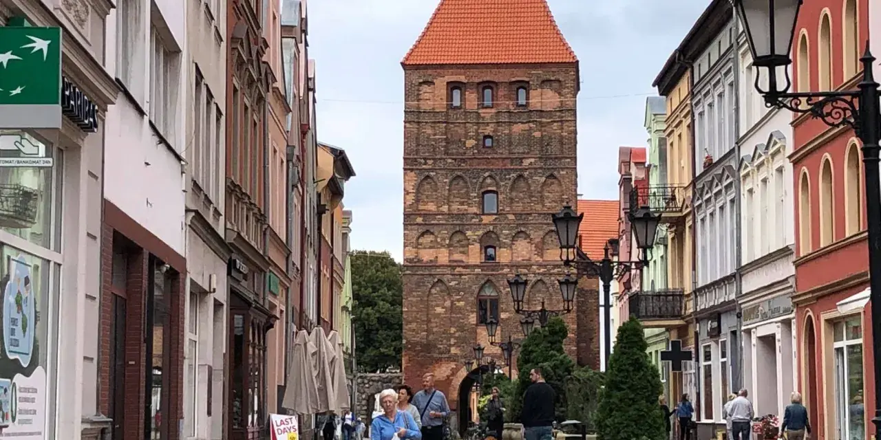 Spacer po urokliwej uliczce z kolorowymi kamienicami, prowadzącej do zabytkowej bramy człuchowskiej.