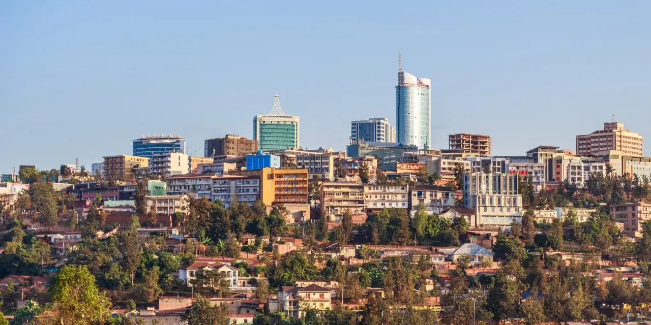Widok na Kigali, Rwanda. Miasto rozwija się, a nowoczesne budynki górują nad zielonymi wzgórzami. Czy Rwanda jest bezpieczna? Obraz sugeruje spokój i postęp.