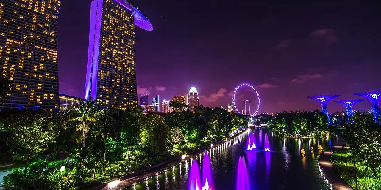 Nocny Singapur z Marina Bay Sands, diabelskim młynem i świetlistymi drzewami. Marzenie o wizie do Singapuru staje się rzeczywistością.