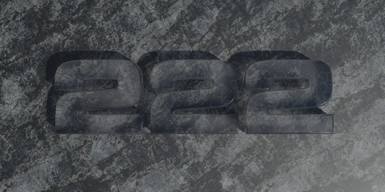 Trzy przezroczyste cyfry 2, ułożone obok siebie na kamiennym tle. Liczba 2222 ma znaczenie w numerologii, symbolizując równowagę i harmonię.