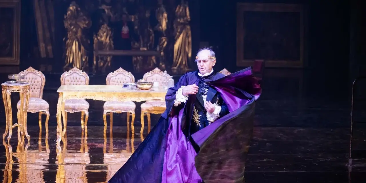 Aktor w purpurowej pelerynie, w teatralnej scenografii, budzi pytanie: misterium co to?