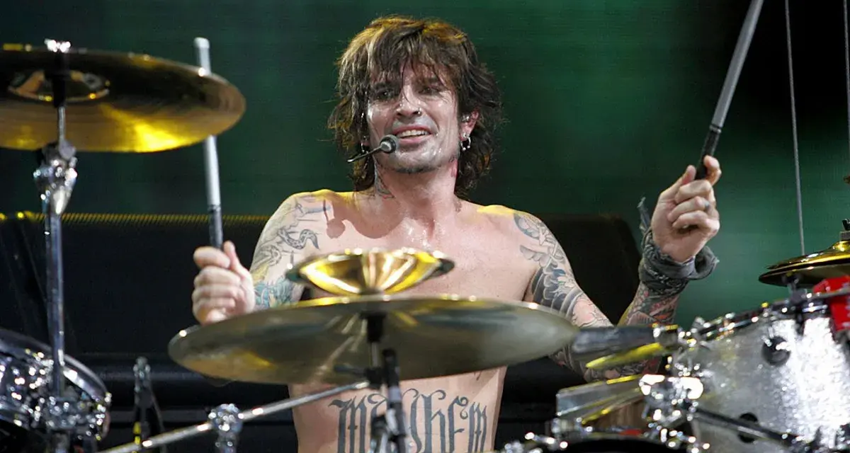 Tommy Lee, batteur du groupe, frappe sur sa batterie, torse nu, tatoué, en plein concert.