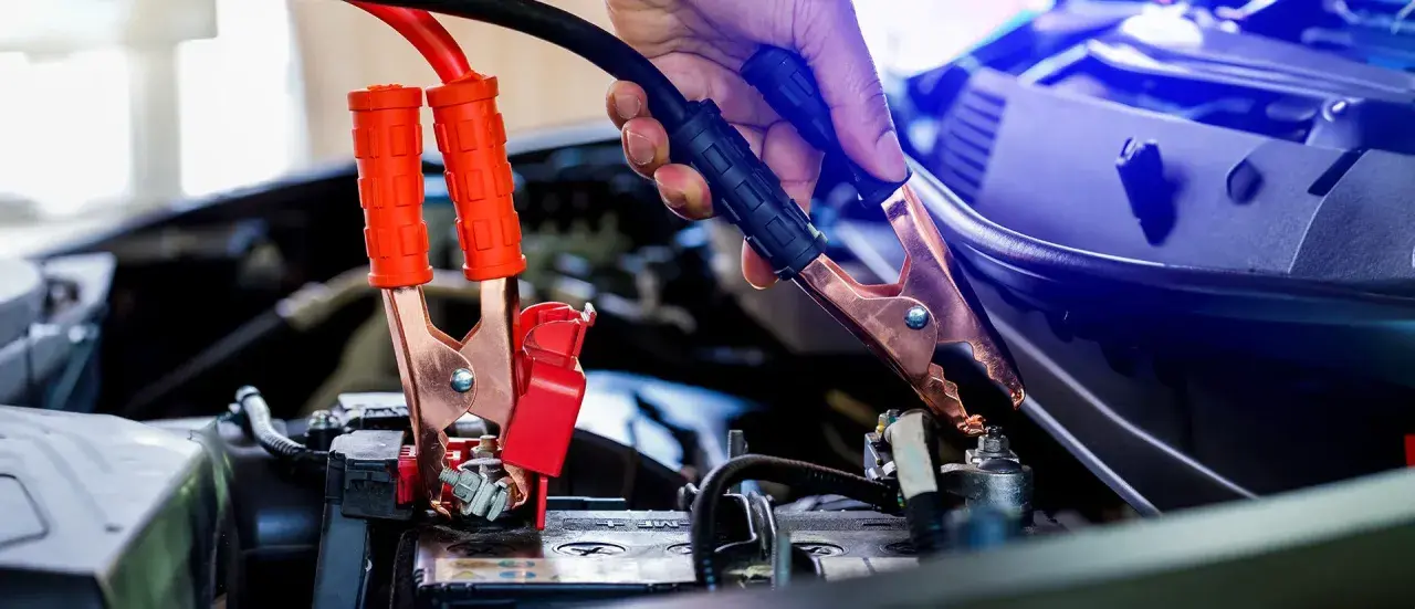 Starthilfe: Rote Klemmen an der Batterie, dann schwarze. Welcher Pol zuerst? Die rote Klemme wird zuerst am Pluspol befestigt, dann die schwarze am Minuspol.