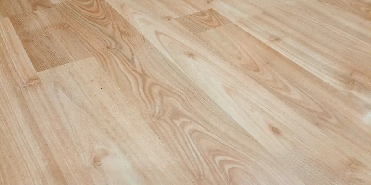 Jasne panele winylowe z widocznymi, naturalnymi rysami imitującymi drewno.