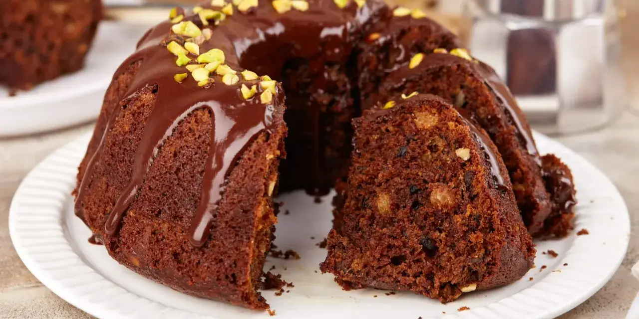 Pyszna babka na oleju, polana czekoladą i posypana pistacjami, czeka na kawę.