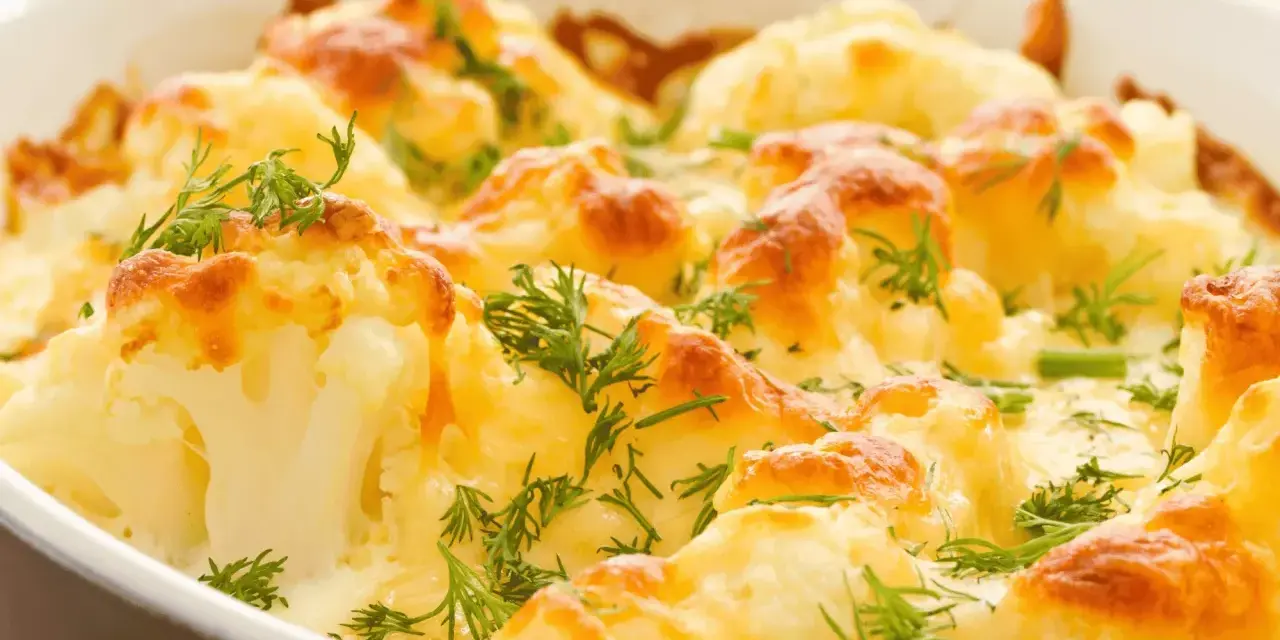 Coliflor al horno gratinada con queso y hierbas frescas. Un plato reconfortante y delicioso.