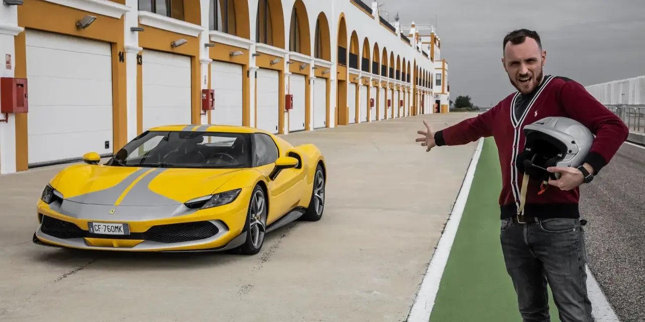 Żółte Ferrari 296 GTB z szarymi pasami na torze wyścigowym. Obok stoi mężczyzna z kaskiem, zapraszając do przejażdżki.