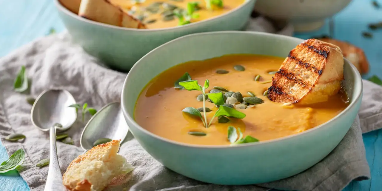 Cremige Kürbissuppe mit geröstetem Brot und Kürbiskernen. Perfekt für leichte, wohltuende schonkost rezepte.