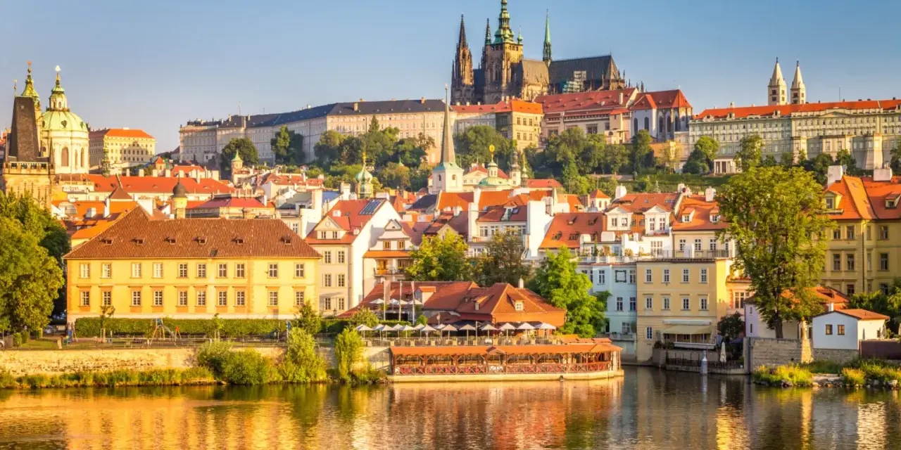 Malownicza panorama Pragi z widokiem na Wełtawę, Zamek Królewski i urokliwe kamienice. Idealne miejsce na odkrywanie atrakcji Pragi i okolic.