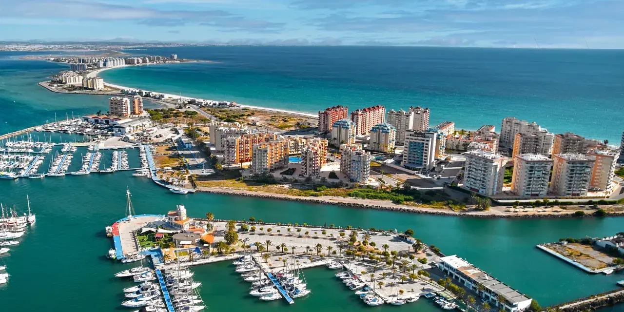 Widok na la Manga, Hiszpania: luksusowe apartamenty i pełen jachtów port nad turkusowym morzem.