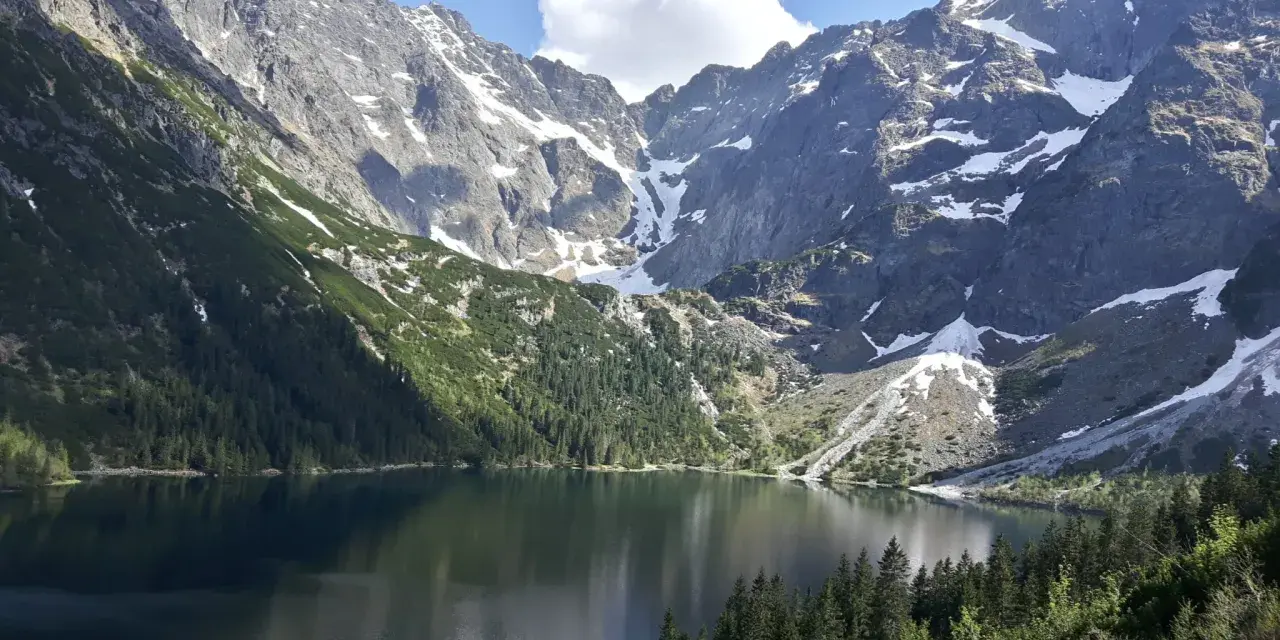 Majestatyczne góry otaczają spokojne Morskie Oko, odbijając w swojej tafli skaliste szczyty i zielone lasy.