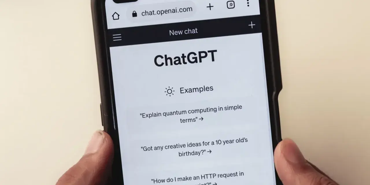 Na ekranie smartfona widać interfejs ChatGPT, gdzie użytkownik może zadawać pytania, np. o komputery kwantowe.