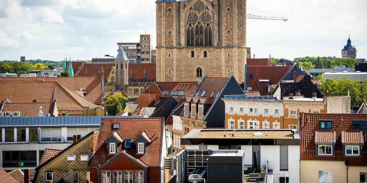 Blick über Dächer auf eine Kirche. Über den Austritt aus der Kirche und steuerliche Folgen wird nachgedacht.