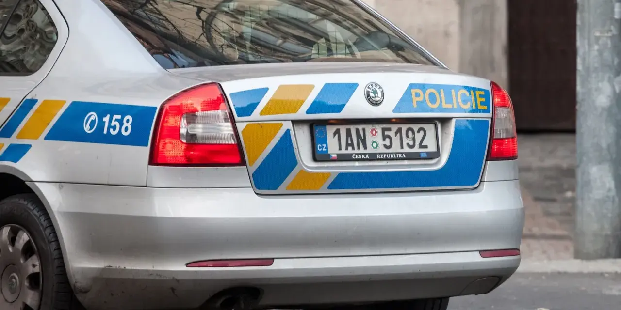 Tylna część srebrnego radiowozu z napisem "POLICIE" i numerem rejestracyjnym 1AN 5192. Widać też numer alarmowy 158.