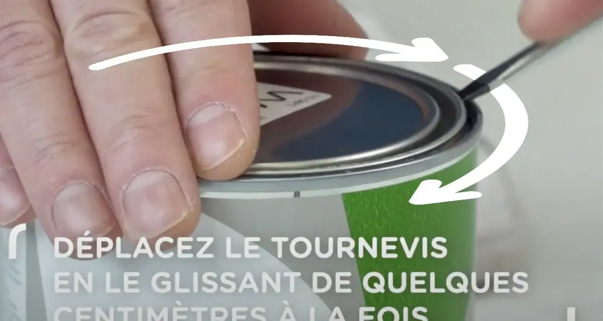 Main tenant un tournevis, on montre comment ouvrir un pot de peinture en faisant levier sur le couvercle.
