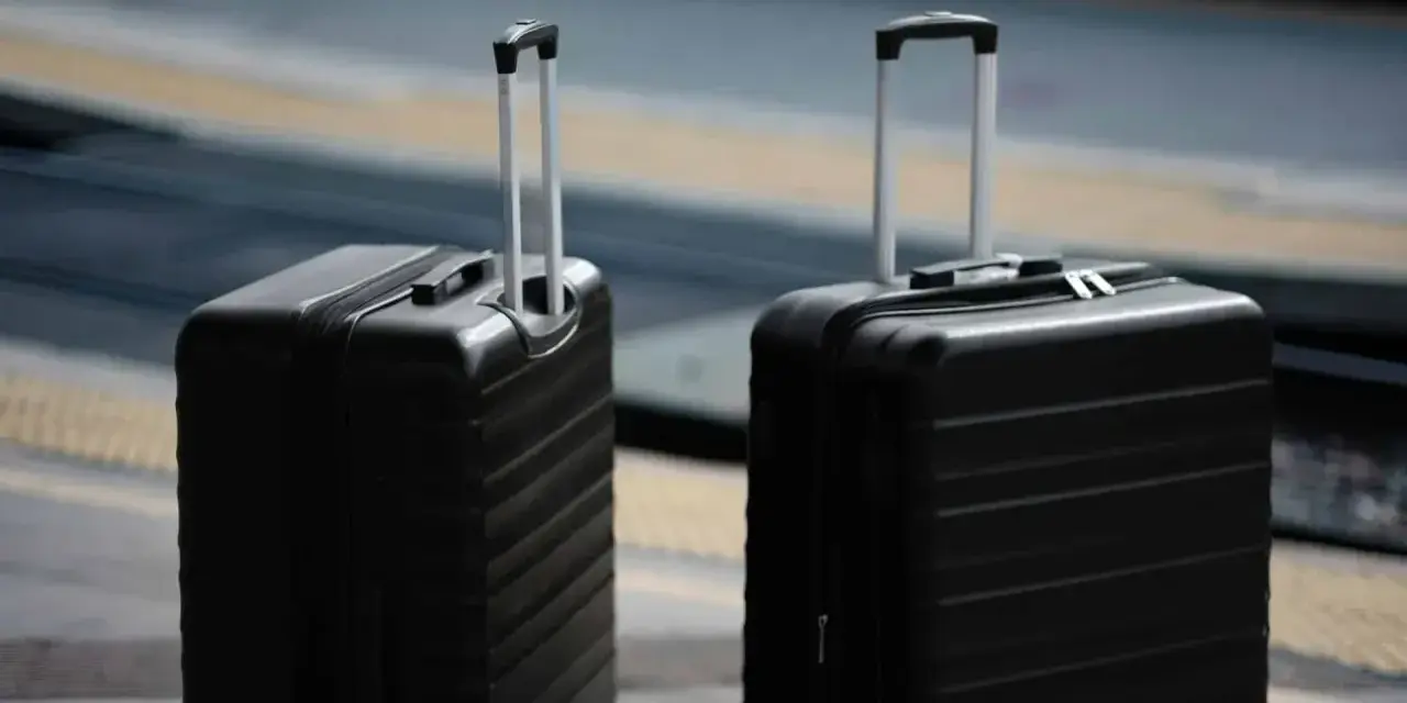 Dwa czarne walizki, idealne jako bagaż podręczny Ryanair, czekają na podróż.