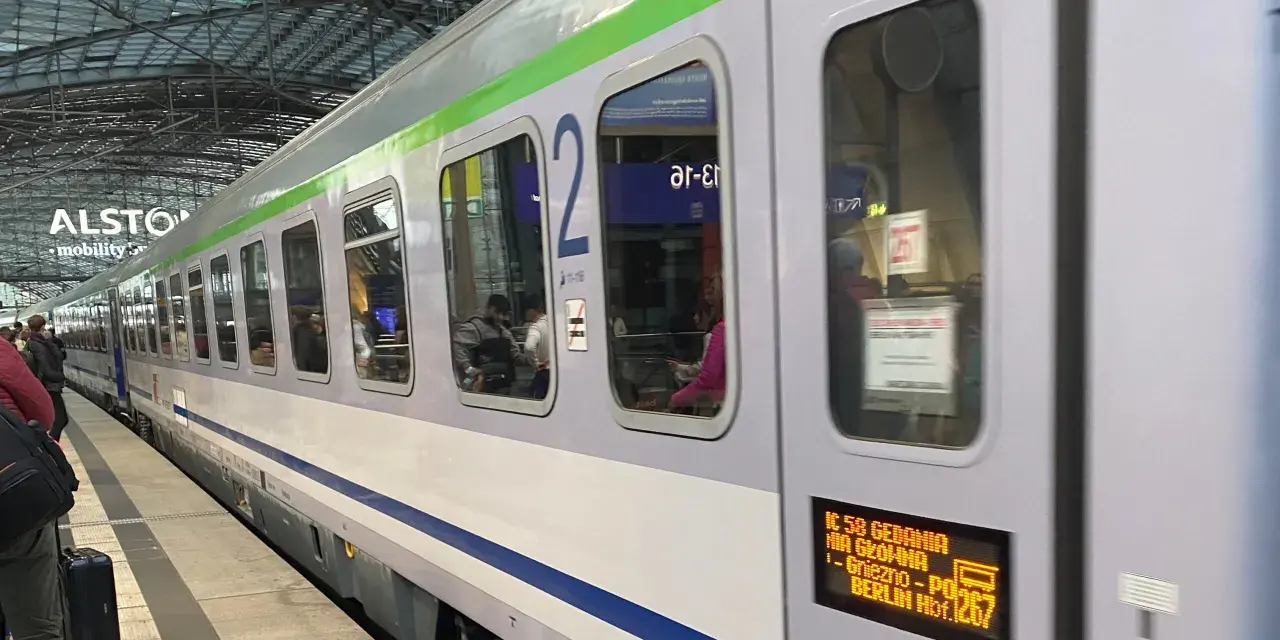 Pociąg IC 58 Gedania z Gniezna do Berlina stoi na peronie. Widać pasażerów w środku.