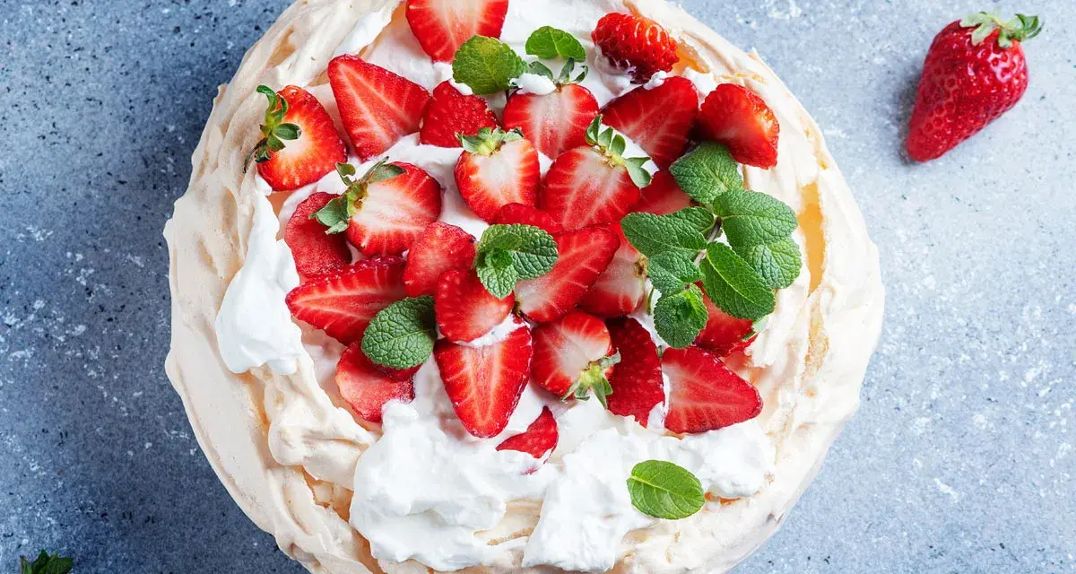 Pyszny deser Pavlova z truskawkami, idealny przepis na bezy z 3 białek. Lekka i chrupiąca beza z bitą śmietaną i owocami.
