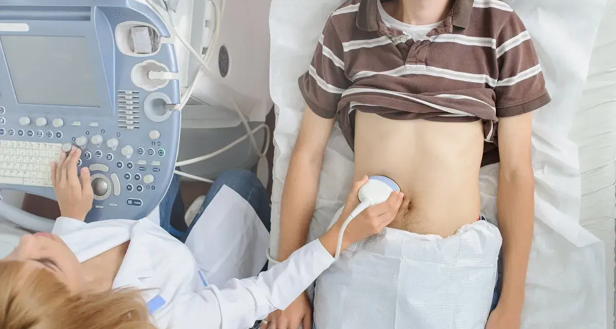 Lekarz wykonuje USG brzucha pacjentowi, szukając przyczyn zapalenia wyrostka sutkowatego i zastanawiając się, jaki antybiotyk będzie najskuteczniejszy.