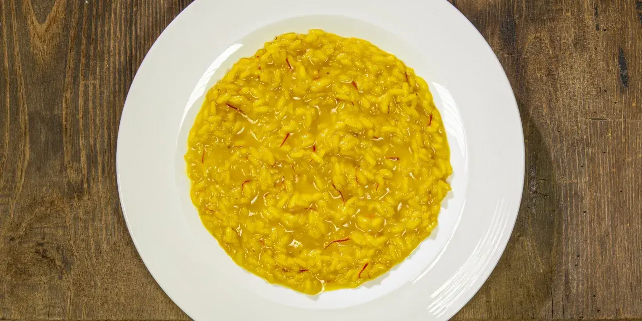 Un cremoso risotto alla milanese, con i suoi fili rossi di zafferano che promettono un sapore autentico.