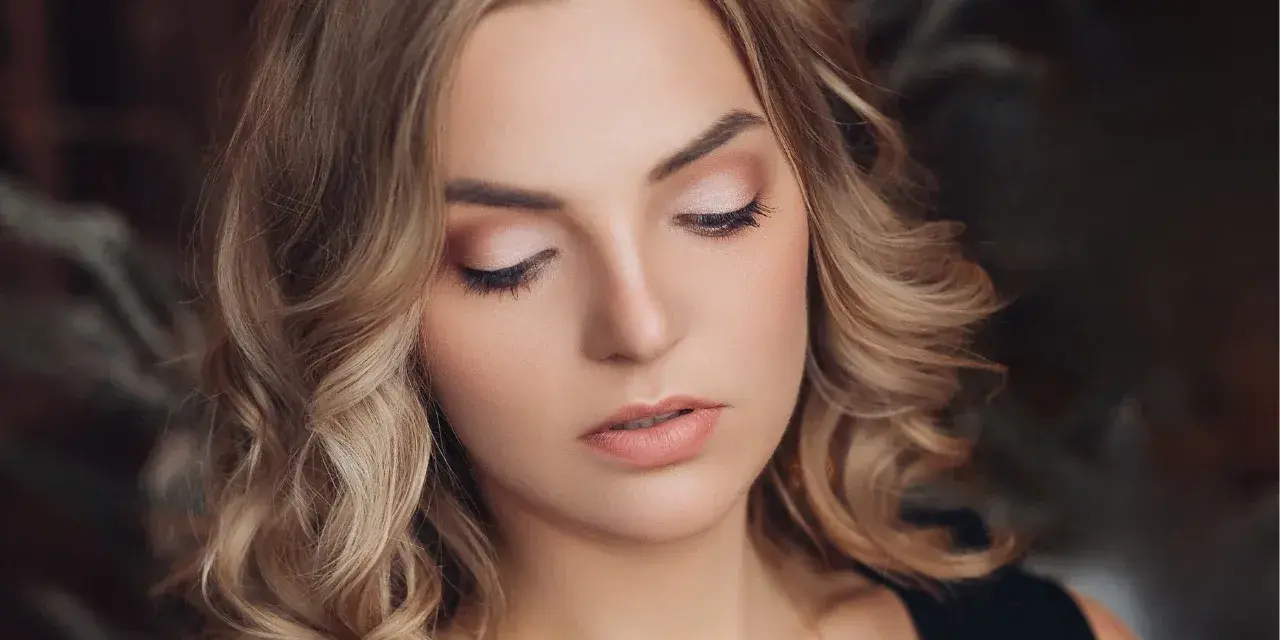 Delikatny makijaż na święta podkreśla urodę kobiety z blond włosami.