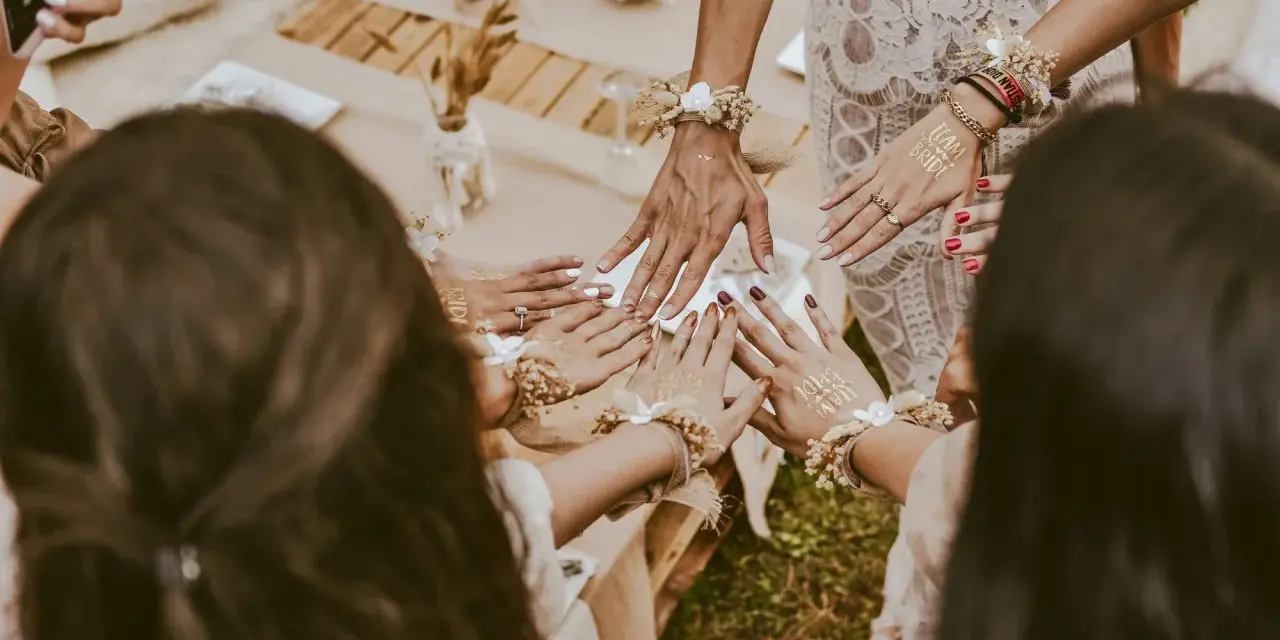 Dłonie ozdobione tatuażami "Team Bride" i bransoletkami z kwiatów. Wspaniałe panieńskie pomysły na celebrację!