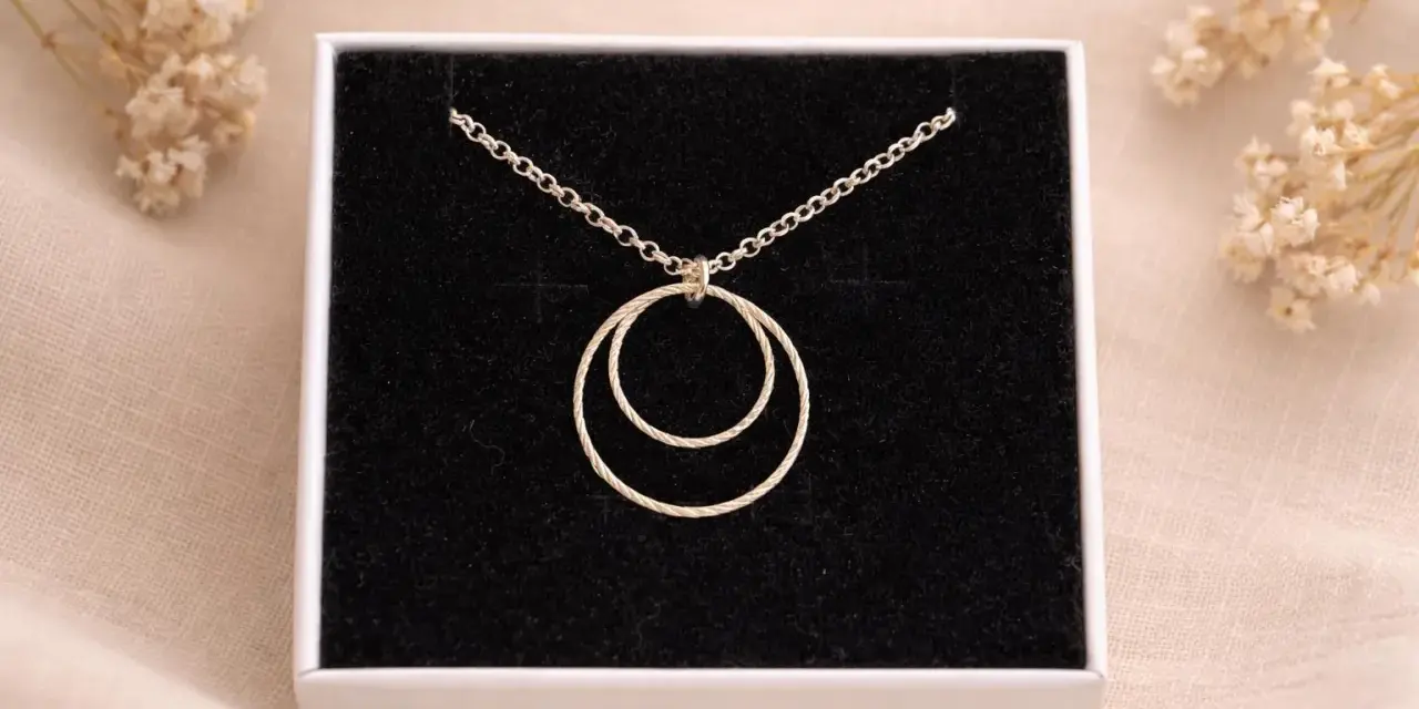Collana con due anelli intrecciati, simbolo di legame eterno e unione.