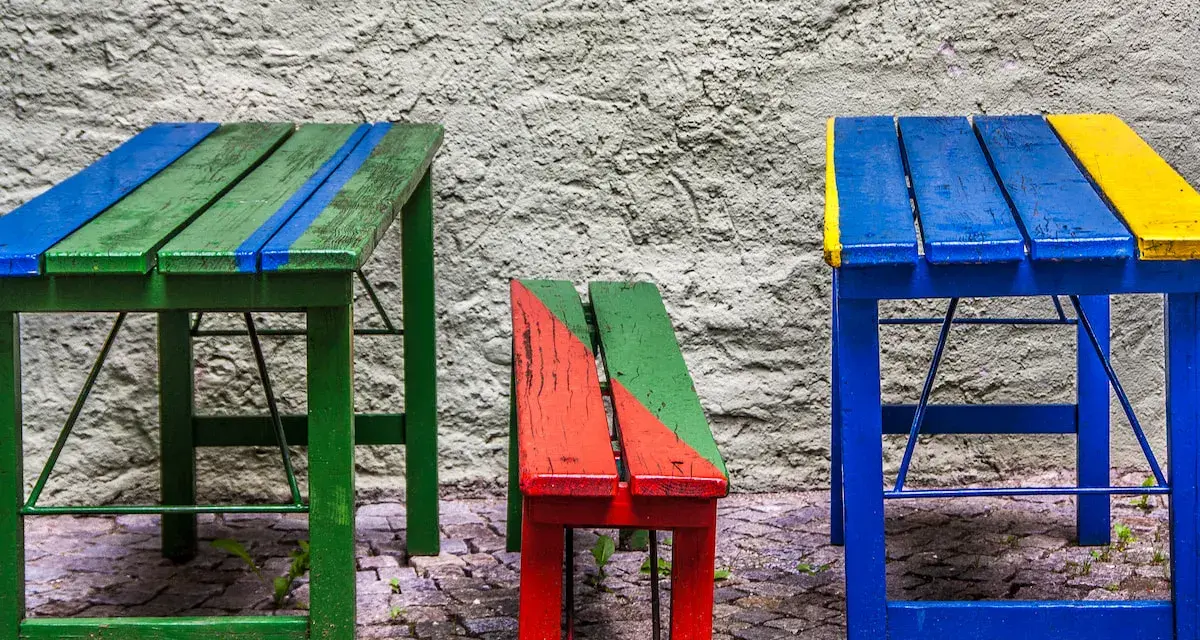 Muebles coloridos, como mesas y bancos, hechos con **objetos reciclados fáciles de hacer**.