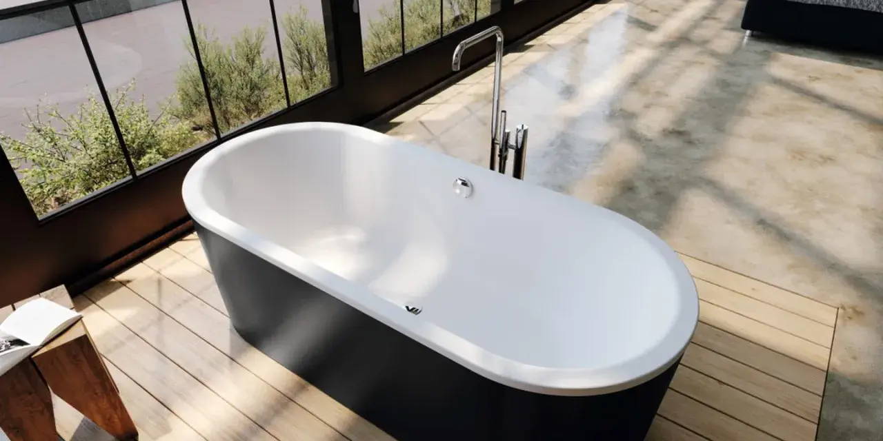 Vasca da bagno freestanding nera e bianca, con rubinetteria a colonna. L'altezza della vasca da bagno in muratura è ideale per un bagno moderno.