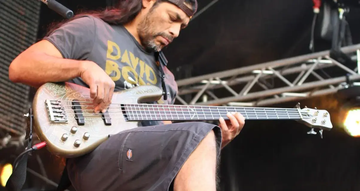 Robert Trujillo z zespołu gra na basie, skupiony na występie.