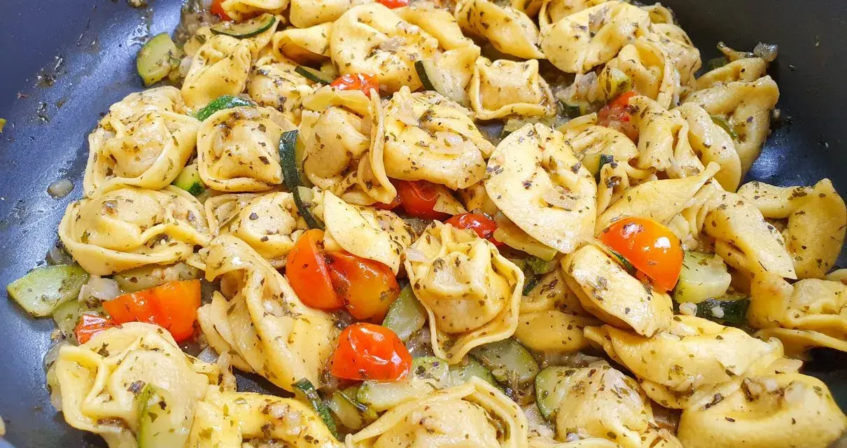 Pyszne danie z tortellini na obiad, z pomidorkami koktajlowymi i cukinią, doprawione ziołami.