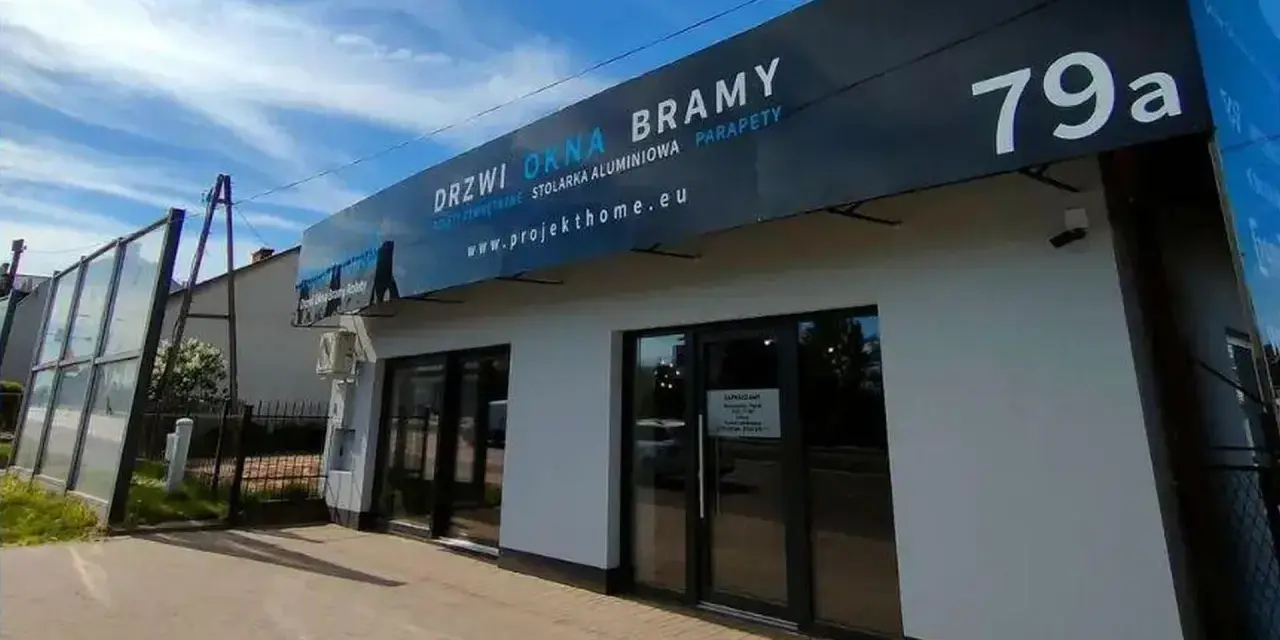 Nowoczesny salon z oknami i drzwiami, z szyldem "DRZWI OKNA BRAMY" i numerem 79a.
