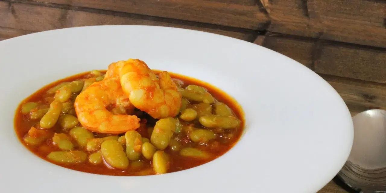 Plato de verdinas con langostinos, un guiso casero lleno de sabor.