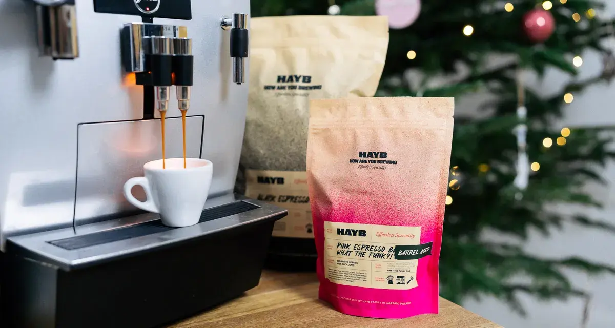 Espresso z ekspresu Jura, obok paczki kawy HAYB "Pink Espresso Barrel Aged". W tle choinka.
