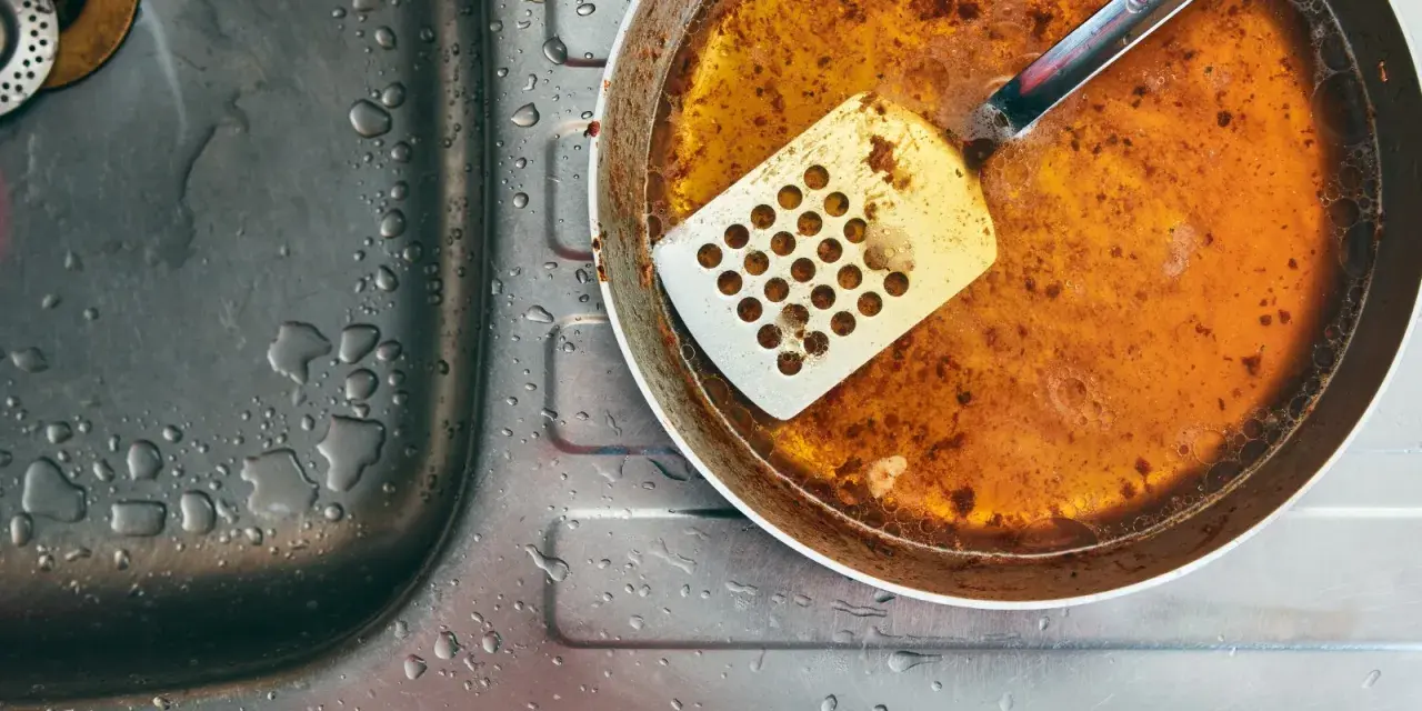 Zlepek zużytego oleju gastronomicznego na patelni obok zlewu.
