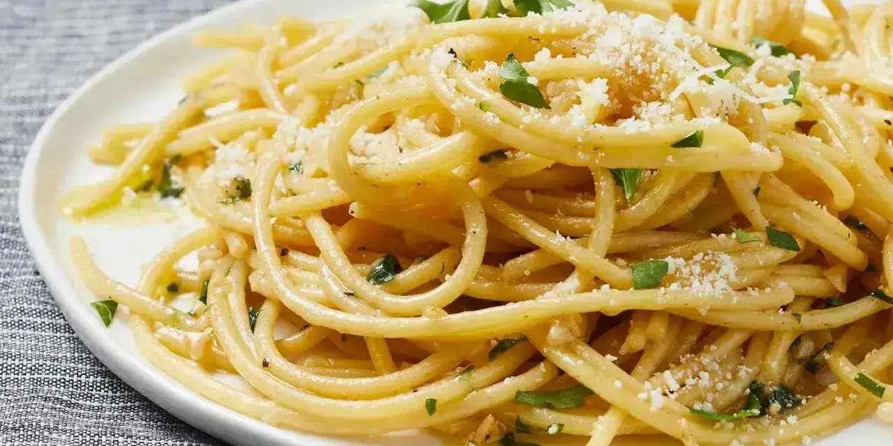 Pyszny makaron aglio e olio, idealny pomysł, z czym zrobić makaron na szybko. Posypany parmezanem i natką pietruszki.
