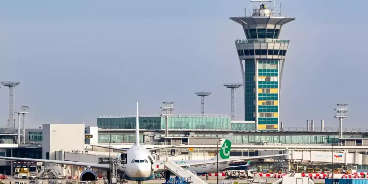 Wieża kontroli lotów i samoloty na lotnisku Orly.