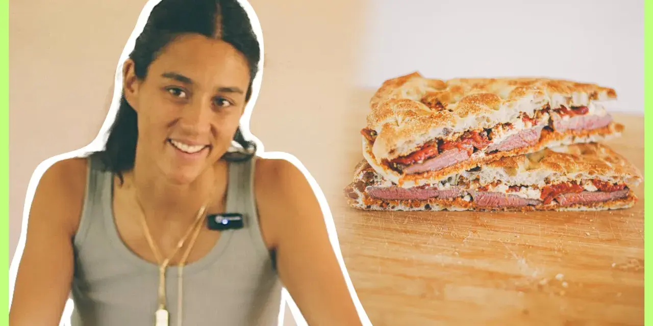 Mujer sonriente junto a un pepito de ternera cortado en dos, mostrando el relleno de carne, queso y pimientos.