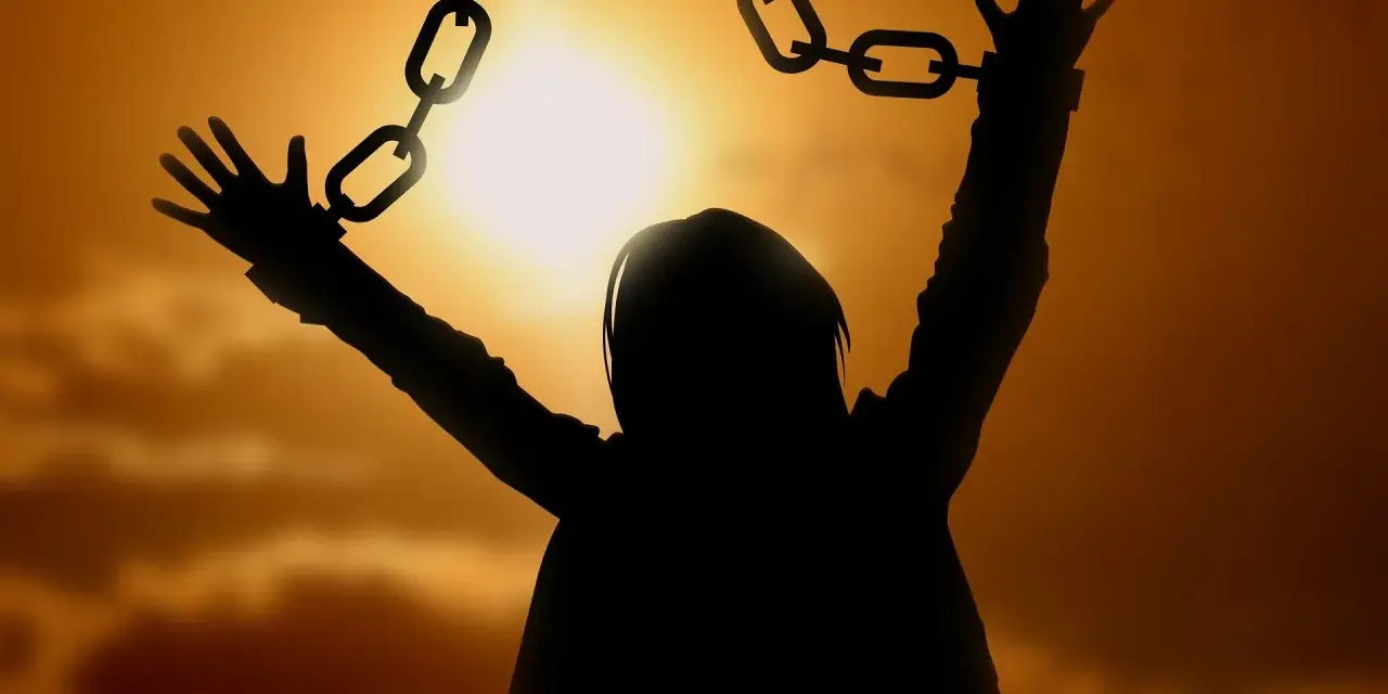 Silhouette einer Person, die sich von Ketten befreit, symbolisiert die Vergebung, wie sie in der Bibel gelehrt wird.