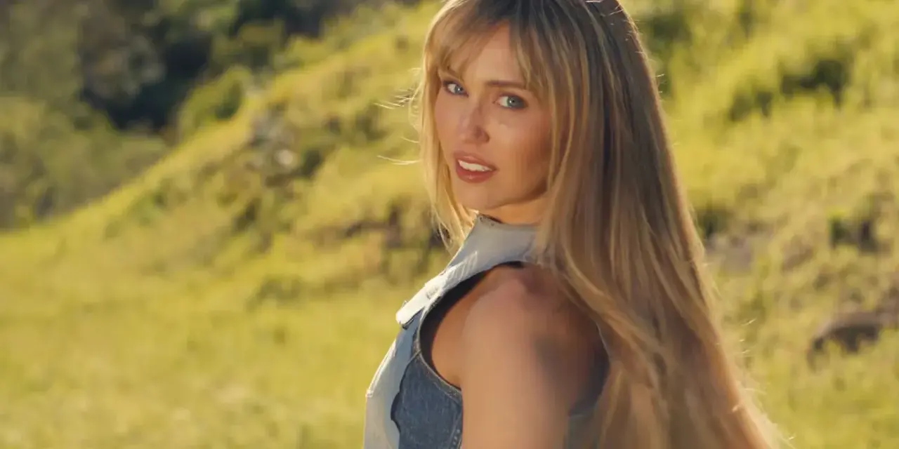 Miley Cyrus w nowej piosence, w letniej stylizacji, na tle zielonych wzgórz.