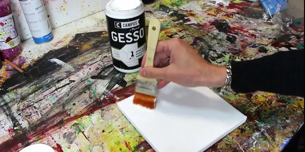 Préparation d'une toile pour faire de la peinture sur toile. Une main applique du gesso blanc avec un pinceau sur la surface vierge.