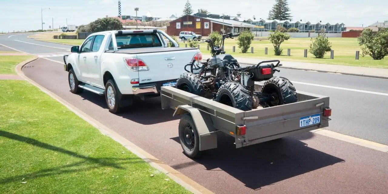 Un quad è trasportato su un rimorchio, parte integrante del veicolo, pronto per l'avventura.