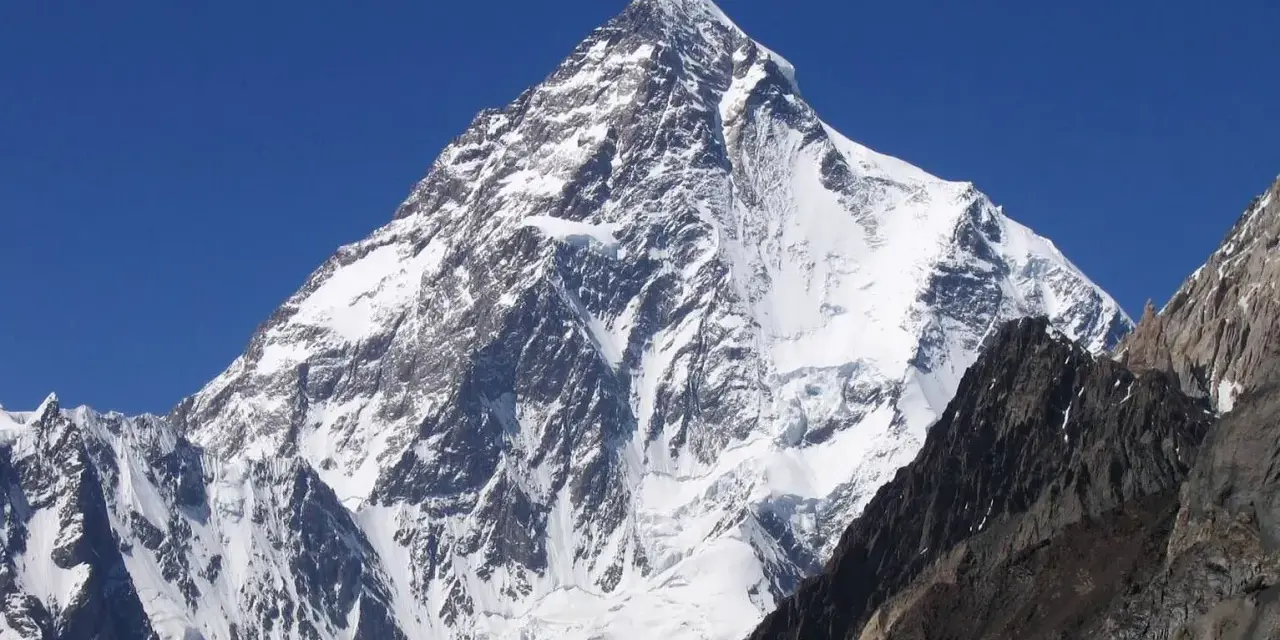 Lodowy gigant K2, najwyższy szczyt Karakorum, wznosi się dumnie na tle błękitnego nieba.