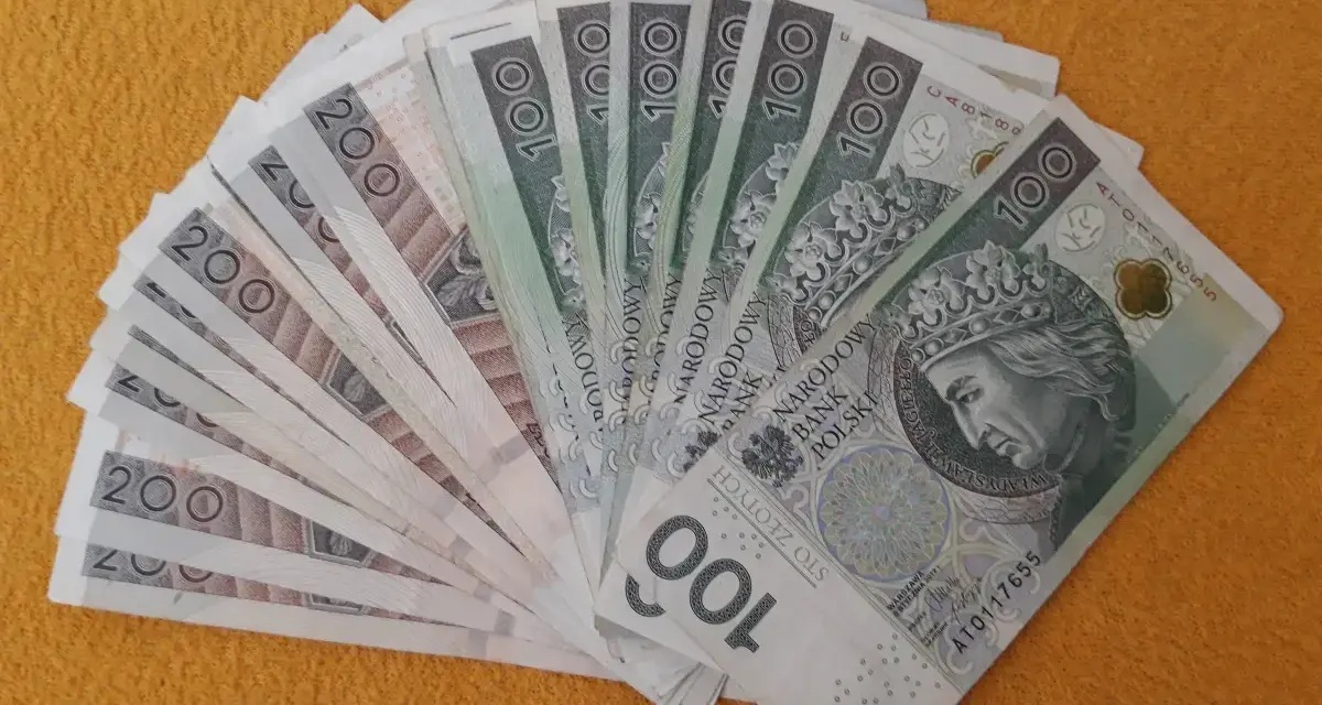 Stos banknotów 100 i 200 zł, gotowy na darowiznę dla dziecka.