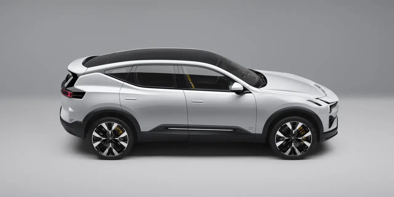 Srebrny SUV Polestar 3 z czarnym dachem i żółtymi zaciskami hamulcowymi, widziany z boku.
