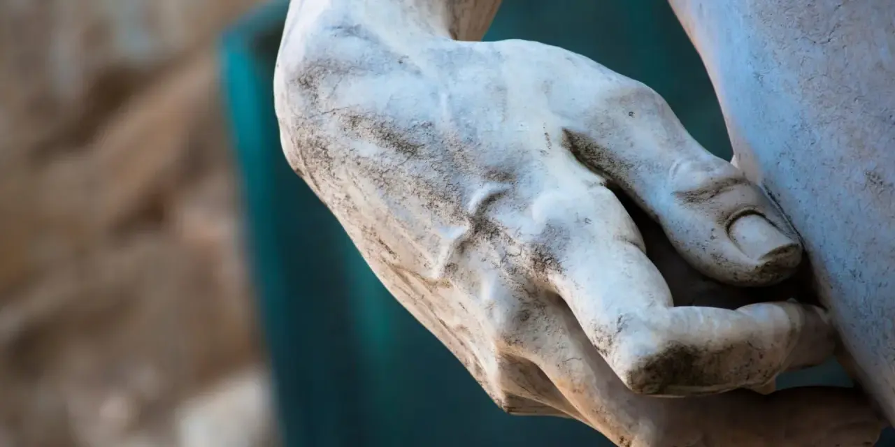 Détail d'une main sculptée, évoquant la puissance et la grâce d'une statue de Michel Ange.