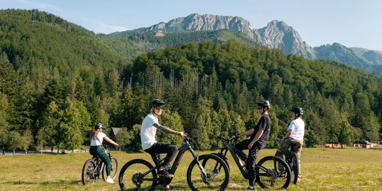 Grupa przyjaciół na rowerach górskich cieszy się pięknymi widokami Tatr. Velo Tatry to idealne miejsce na aktywny wypoczynek.