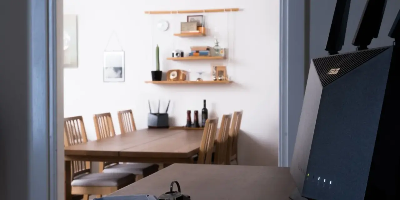 En modern router med wifi 4 ger snabb uppkoppling i hemmet. Nycklar och en blå korthållare ligger på bordet.