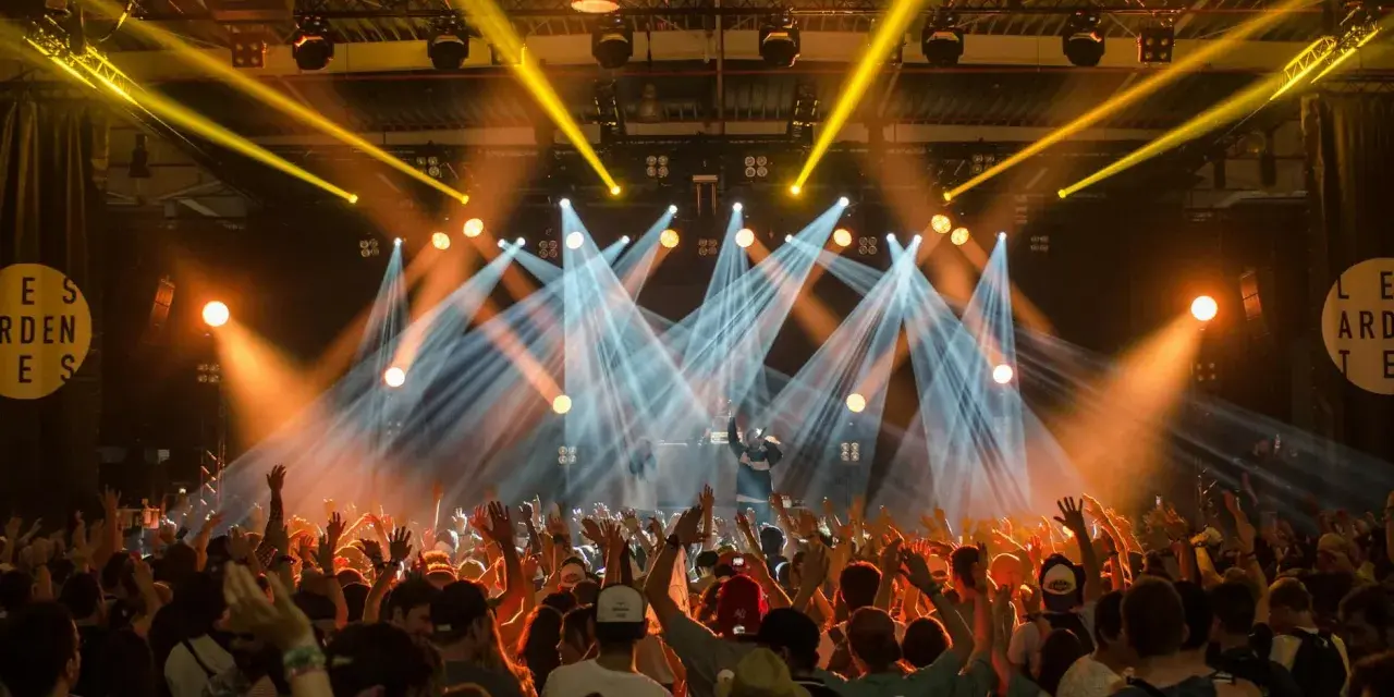 Tłumy na festiwalu muzycznym szaleją pod światłami sceny.