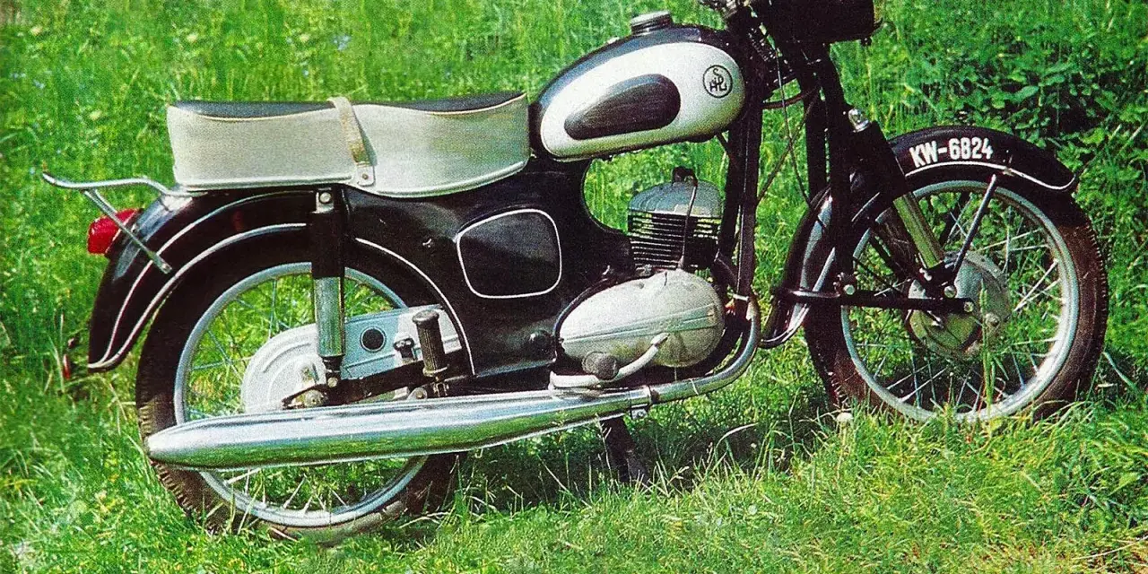 Klasyczny motocykl SHL M11 na tle zielonej trawy. Poznaj jego shl m11 dane techniczne i poczuj ducha minionej epoki.